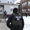 ICE agents approach a house before detaining two people on Jan. 13 in Minneapolis.