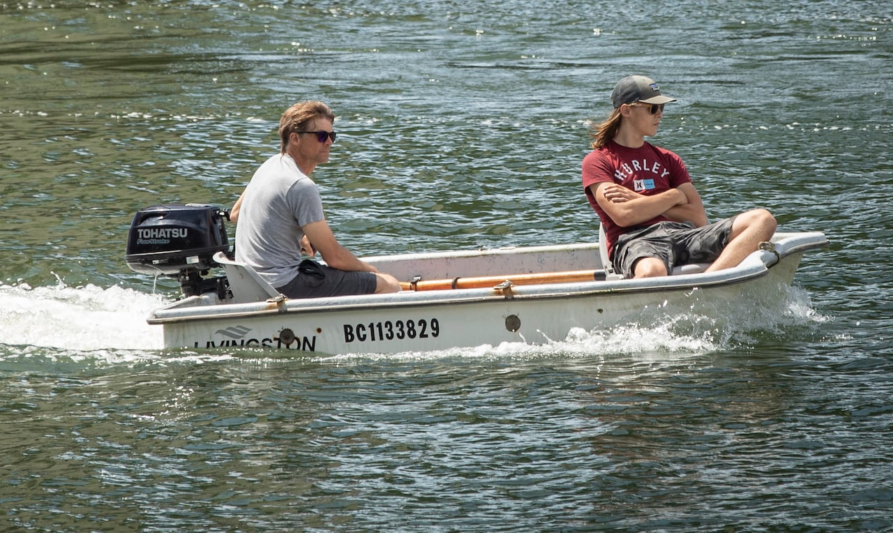 Two people operate a motorboat.