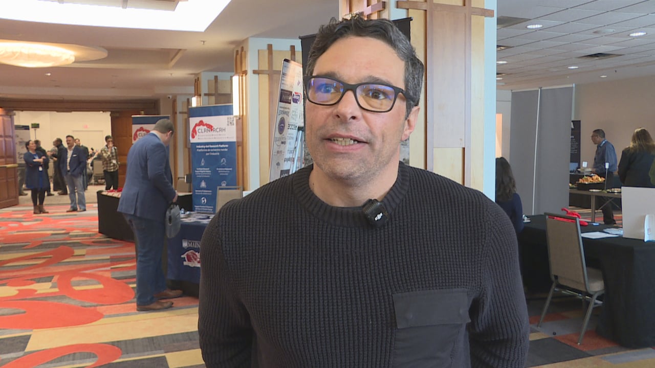 A man in a black shirt with glasses.