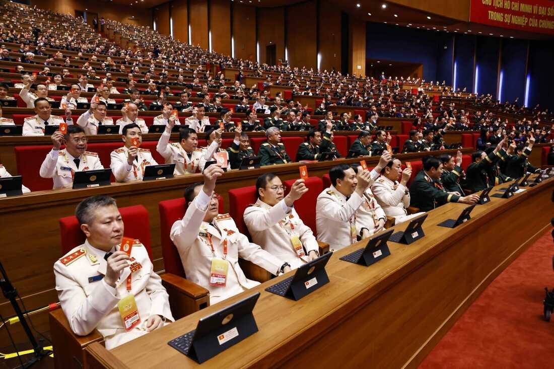 Delegates hold up Communist Party member cards as a vote during a meeting in preparation for the opening of the National Congress in Hanoi, Vietnam, Monday, Jan. 19, 2026.