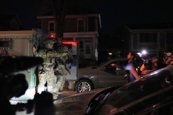 Protesters shout at law enforcement officers after a shooting on Wednesday, Jan. 14, 2026, in Minneapolis. (AP Photo/Abbie Parr)