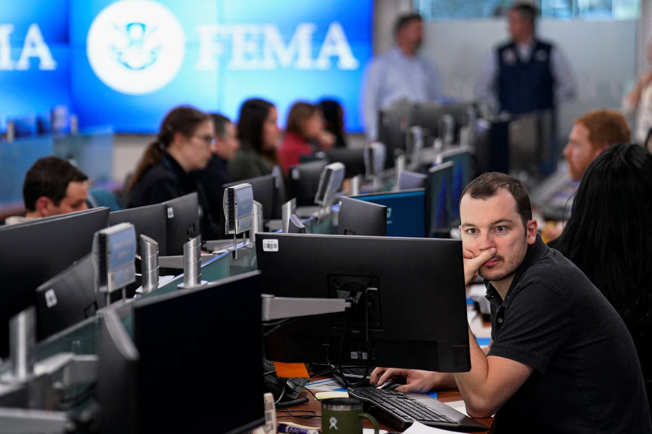 People work in an open-concept office and stare at computer screens.