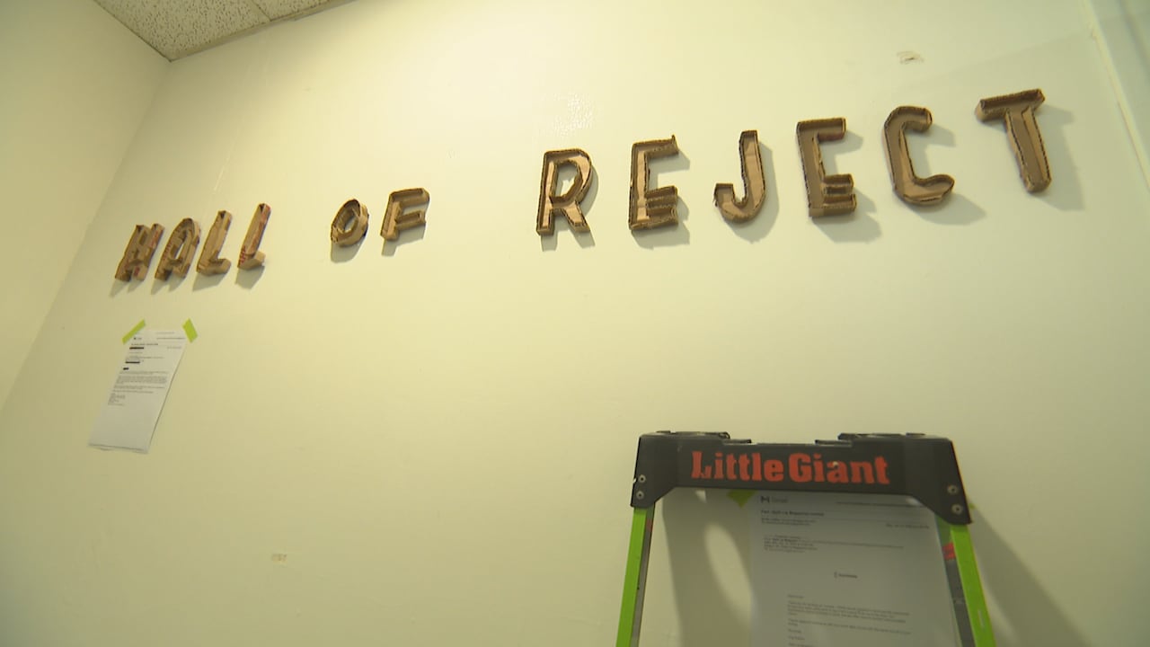 A blank wall with cardboard letters reading "Wall of Reject"