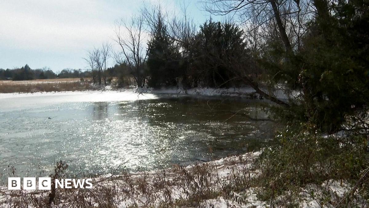 Close up of a pond which has layers of ice over parts of it