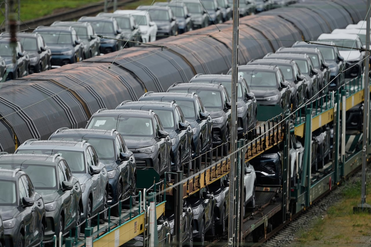 Many cars are seen being shipped via train. 