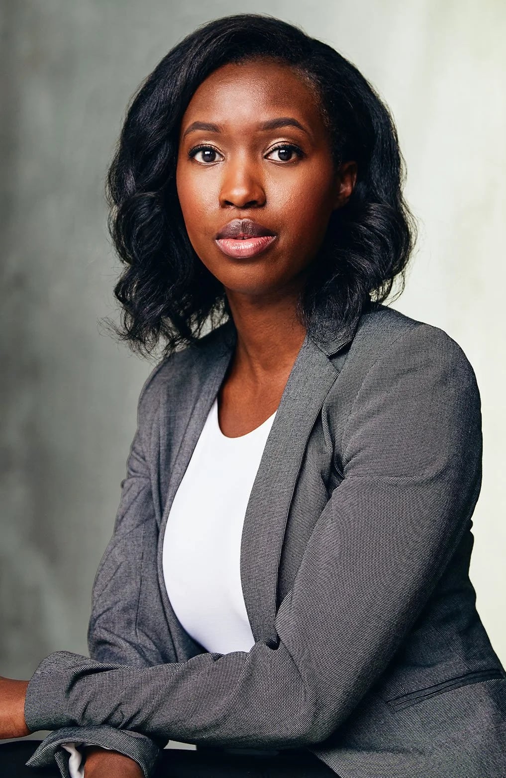 Woman in grey suit poses for photo 