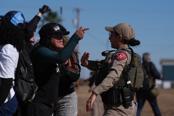 Protesters yell at a Texas state trooper outside the South Texas Family Residential Center detention facility where Liam Ramos and his father are being detained in Dilley, Texas, Wednesday, Jan. 28, 2026. (AP Photo/Eric Gay)