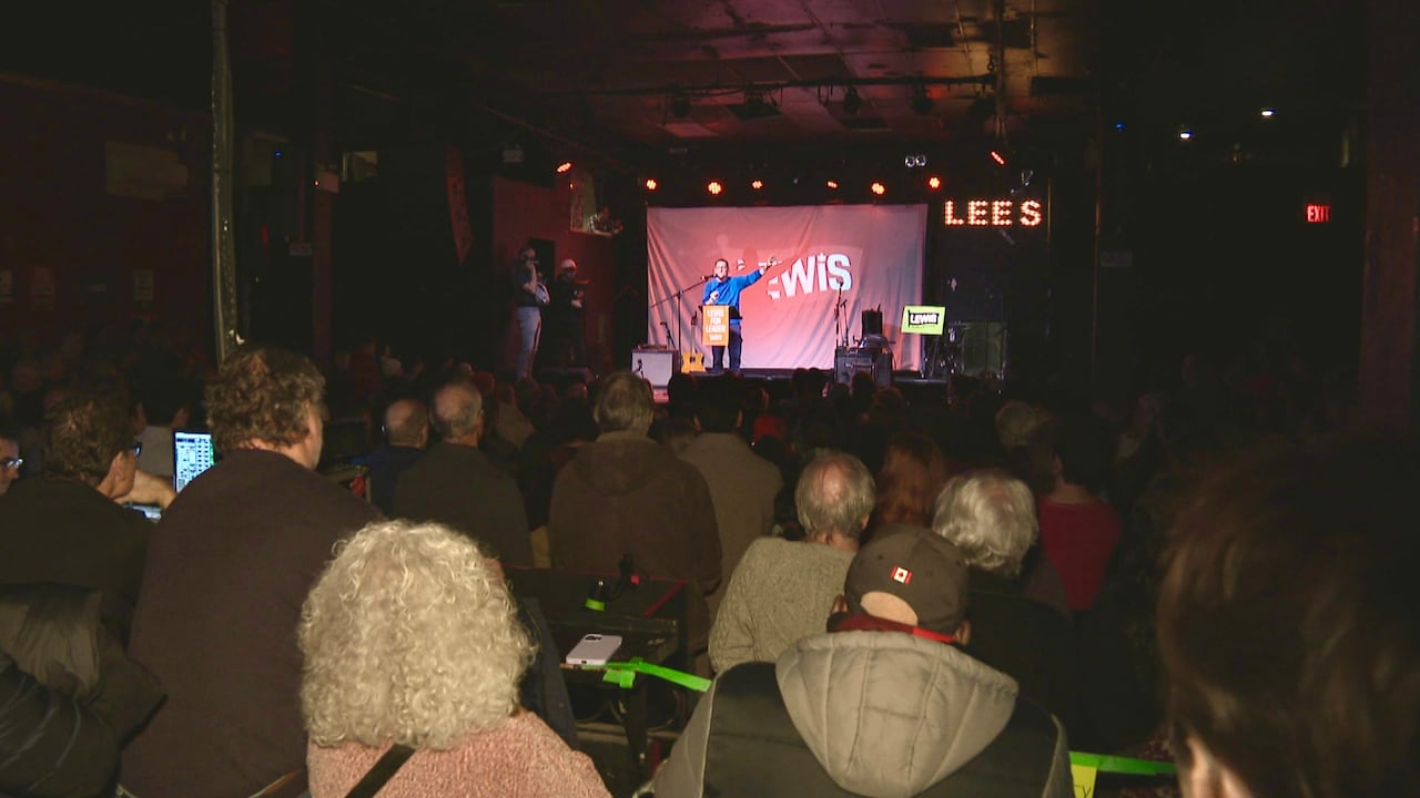 A crowd watches a man on stage.