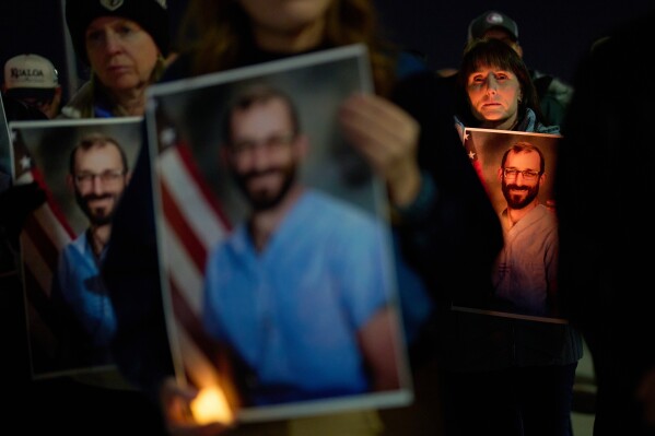 People hold up photos during a vigil for Alex Pretti, who was shot and killed by federal immigration enforcement in Minneapolis, Wednesday, Jan. 28, 2026, in Henderson, Nev. (AP Photo/John Locher)