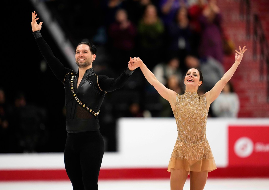 Deanna Stellato-Dudek in a gold dress prepares to bow alongside Maxime Deschamps in a black shirt and pants
