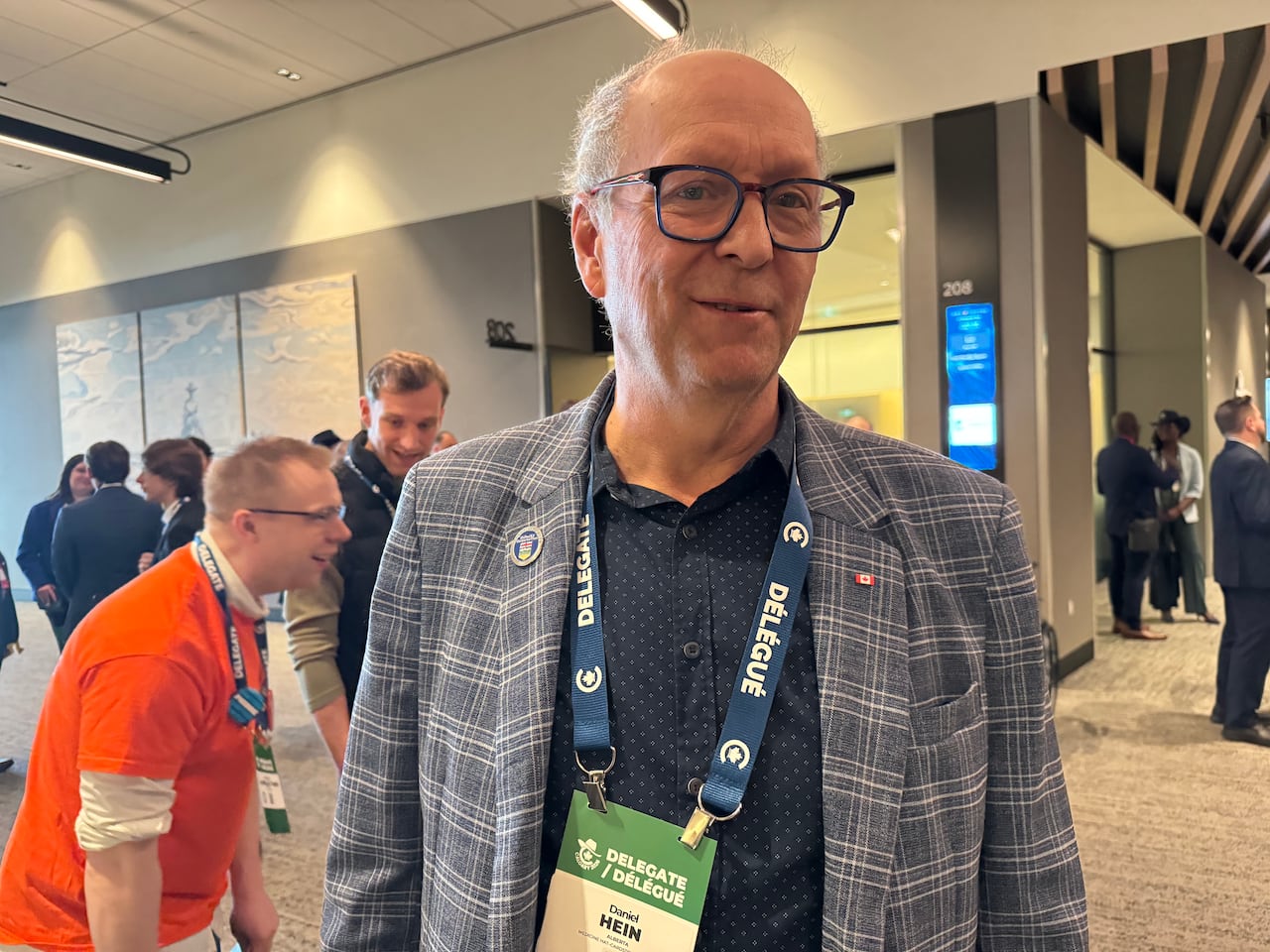 A man wearing a suit jacket smiles at the camera.
