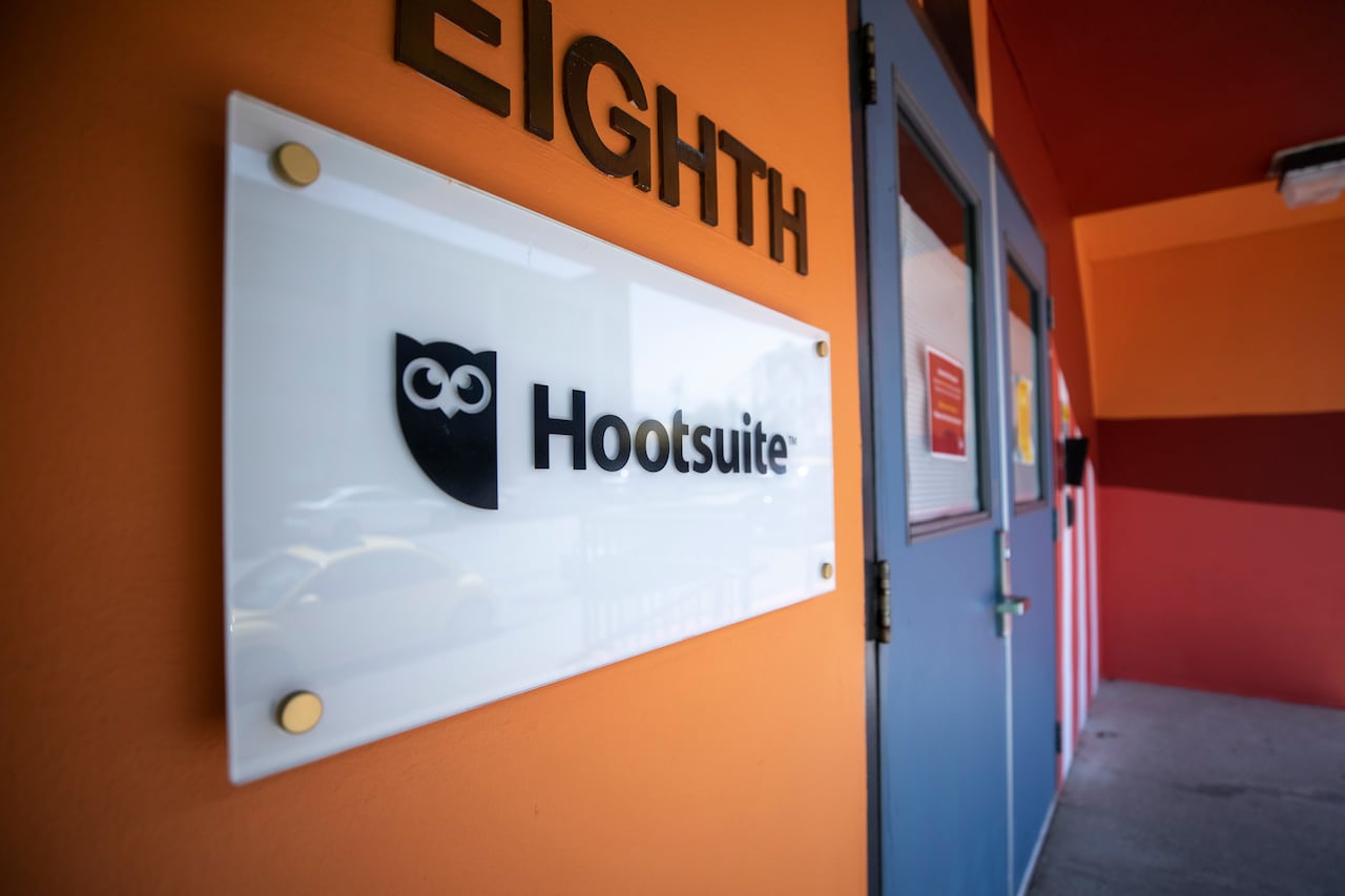 A sign next to a door with an owl and the word 'Hootsuite' on it.