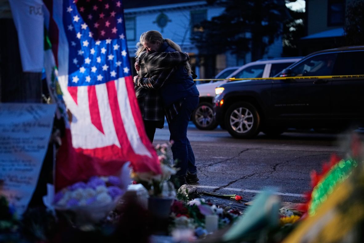 People hug in Minneapolis while visiting a makeshift memorial for Renee Good on January 12. Good, a 37-year-old US citizen, <a href=