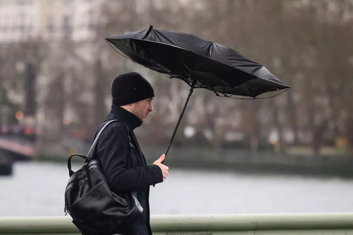 Commuters are battered by strong winds as they cross Westminster Bridge on January 24, 2025