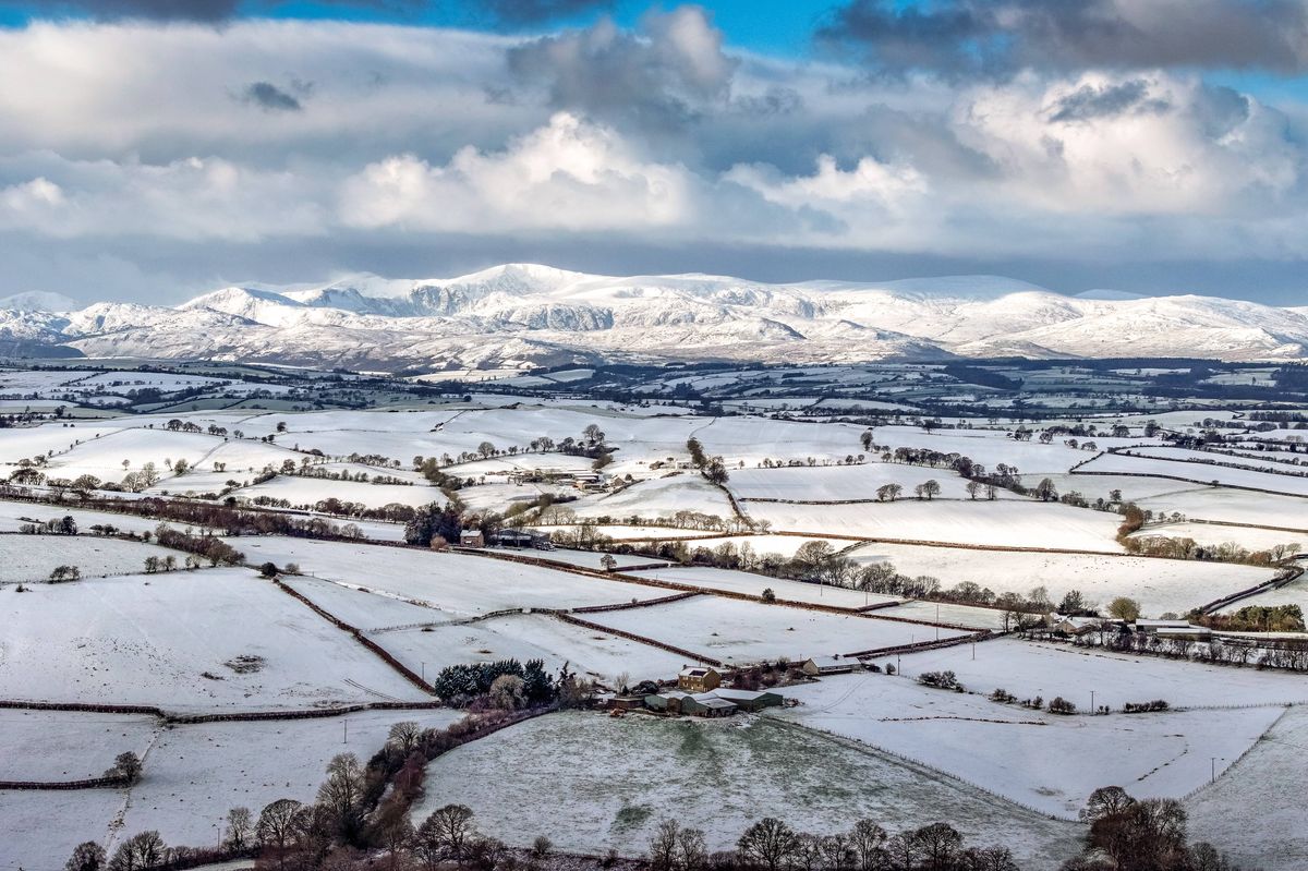 Aerial view, near Llanrwst, snow covers the high ground of Eryri