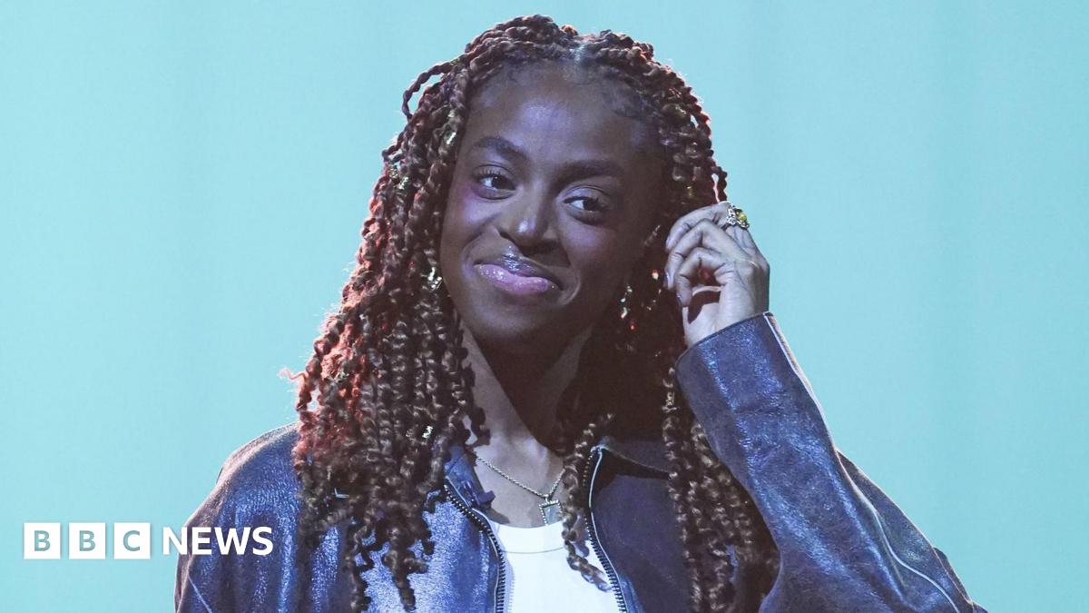 Cat Burns pictured smiling and wearing a leather jacket during filming for the Graham Norton Show in December