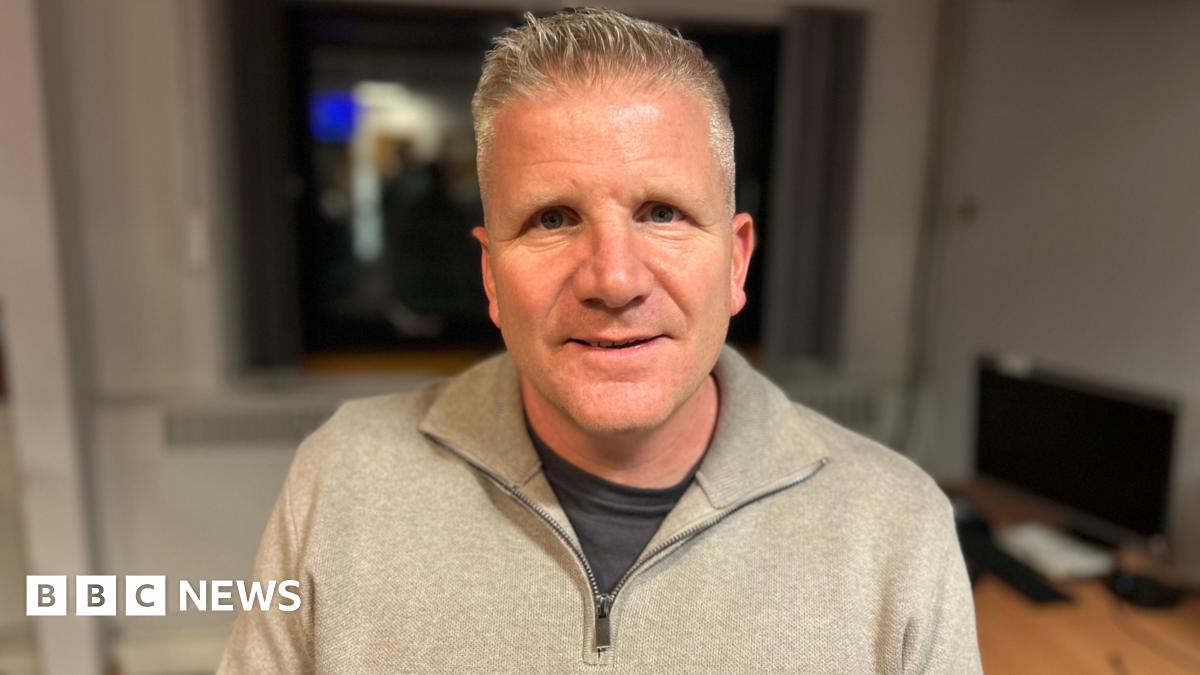 A man walks past a graffiti depicting Venezuelan President Nicolas Maduro in Caracas on January 3, 2026. The colours used in the graffiti are yellow, blue, red and white.