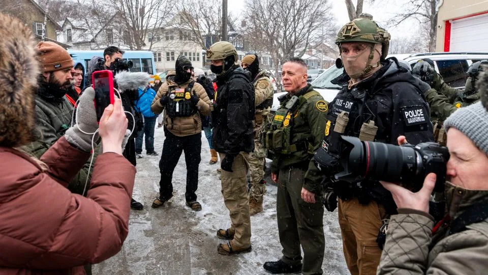 US Border Patrol Commander Gregory Bovino, center, looks on as he is confronted by community members on Wednesday, in Minneapolis. - Stephen Maturen/Getty Images