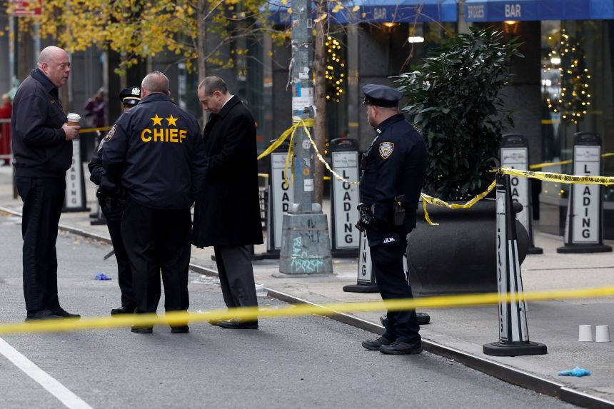 Police officers stand near the scene where the CEO of United Healthcare Brian Thompson was shot and killed in New York City on December 4, 2024.