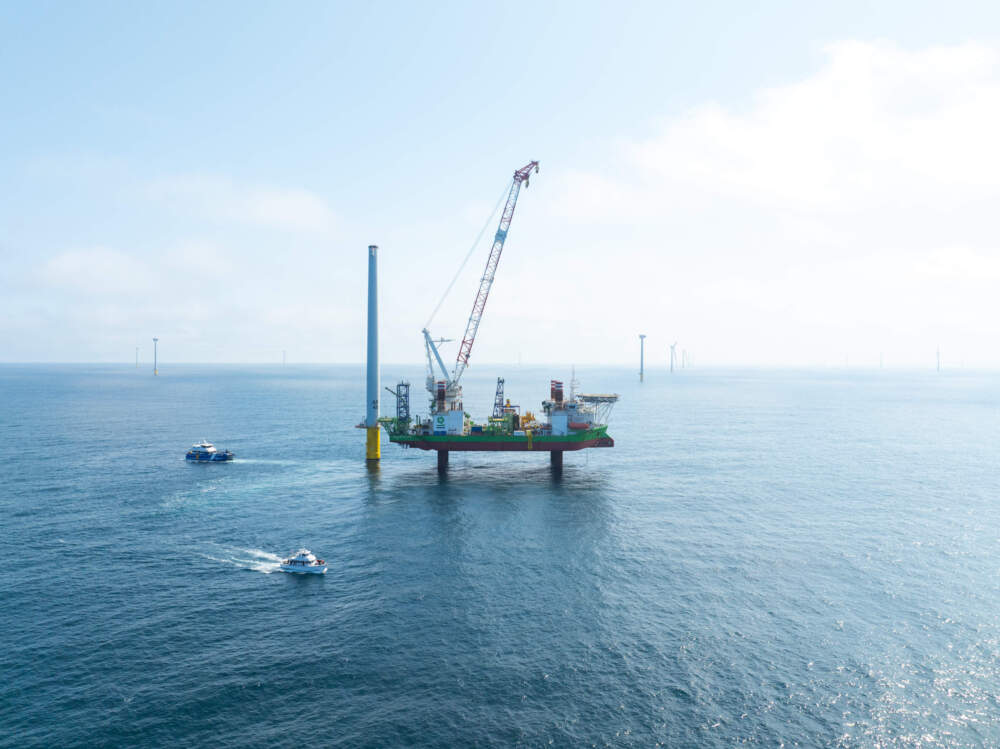 The Sea Installer, a 434-foot long "jack-up vessel" stands next to a partially constructed turbine in the Vineyard Wind project. (David Lawlor/Rhode Island PBS)