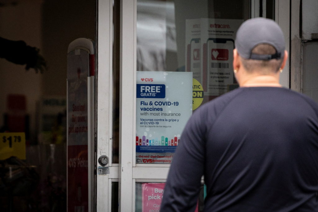 A sign advertises COVID-19 (coronavirus) and flu vaccine shots in Miami