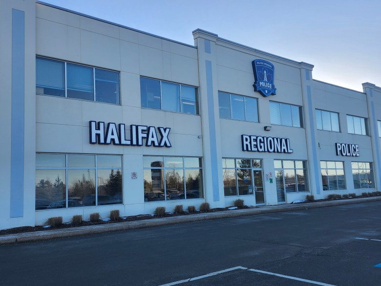 A bland two-story building in a strip mall with the words Halifax Regional Police on the front, and the police department's logo above.