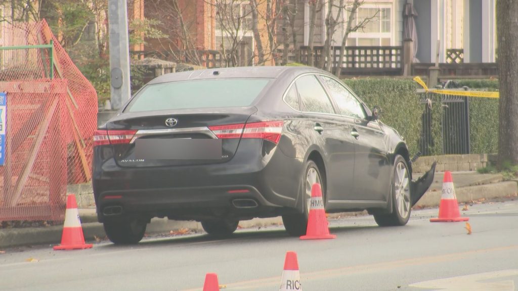 Police cones surround a damaged black sedan