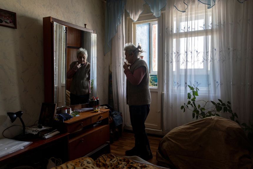Galina Turchin stands in the bedroom of her Kyiv apartment which was left without water, heating and gas.