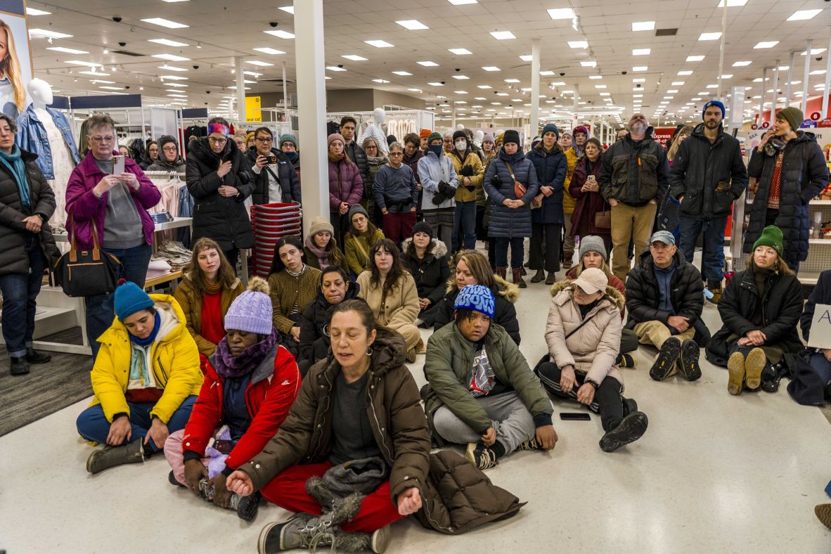 Demonstrators sit and sing inside a Target store in St. Paul on January 19. <a href=