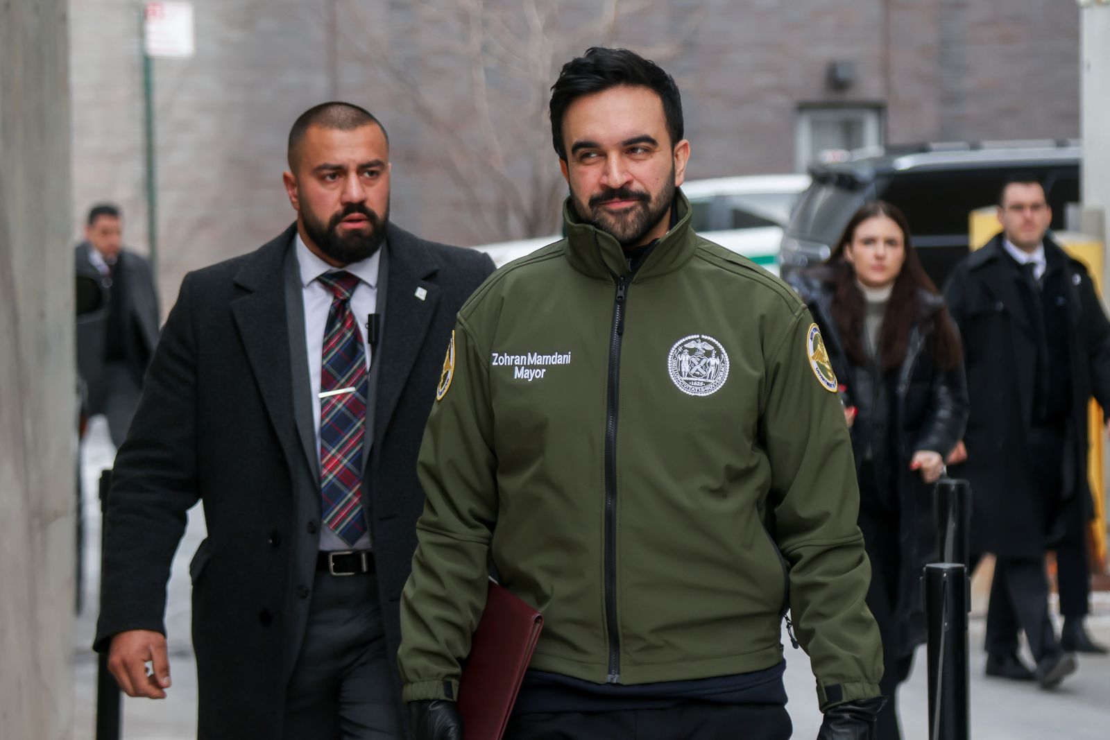 Image may contain Clothing Coat Jacket Accessories Formal Wear Tie Adult Person Glove Car and Transportation