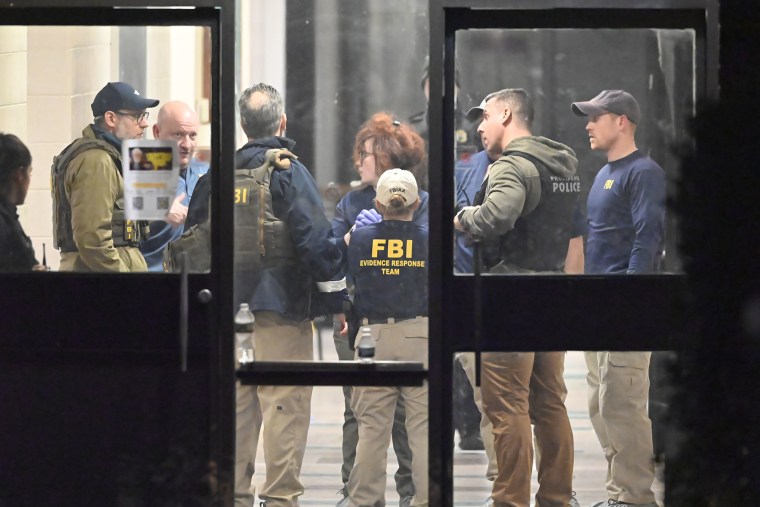 Members of the FBI Evidence Response Team work at the scene of a mass shooting at Brown University in Providence, R.I., Saturday, Dec. 13, 2025.