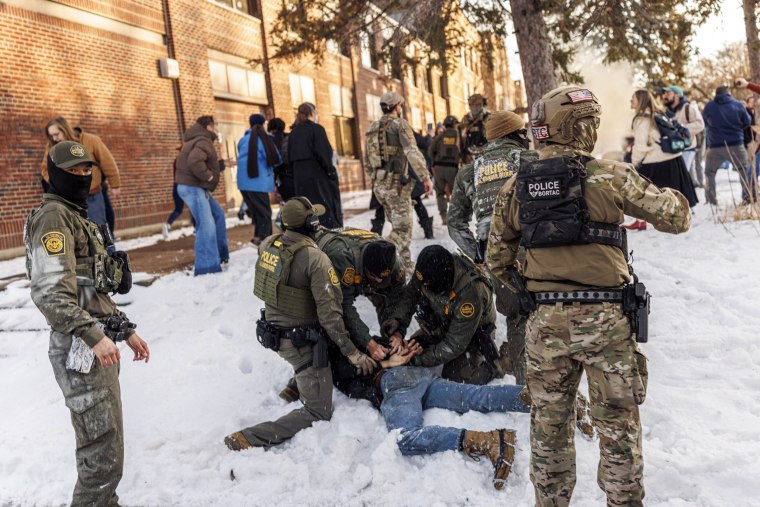 Image: U.S. Border Patrol agents detain a person near Roosevelt High School