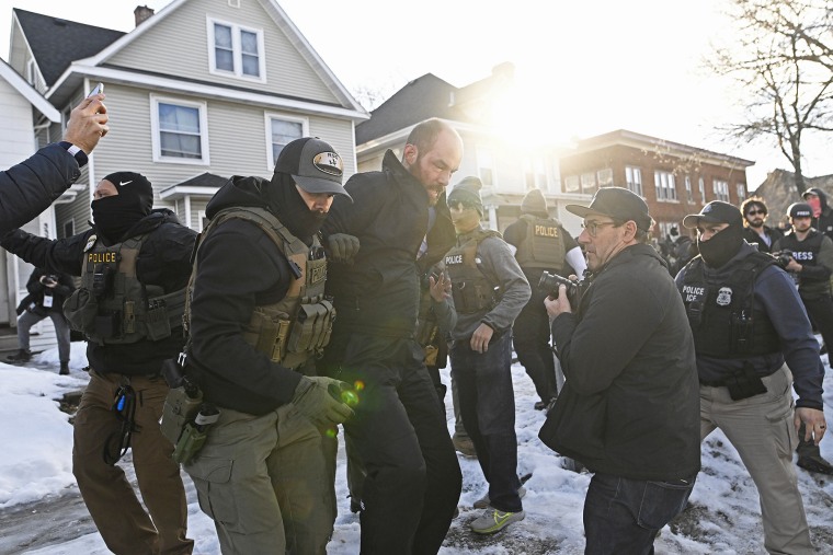 An observer is detained by ICE agents after they arrested two people from a residence on Jan. 13, 2026 in Minneapolis.