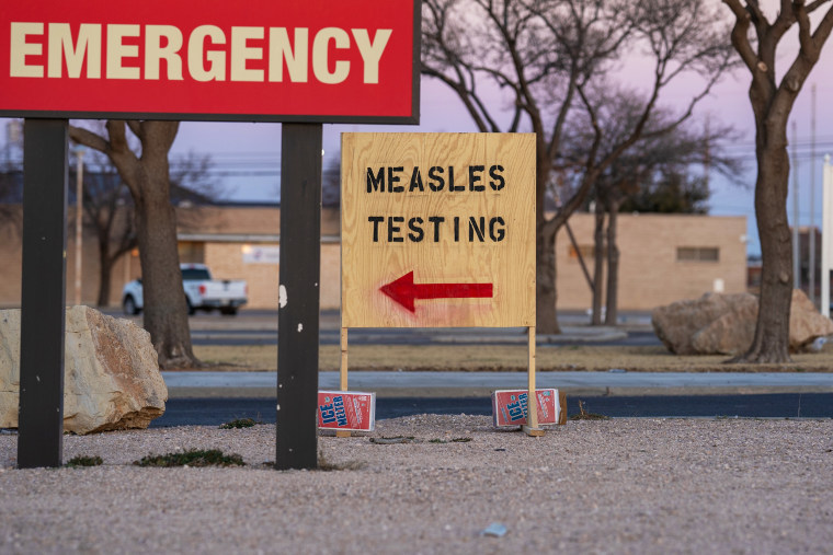 Image: Signs point the way to measles testing in a parking lot of a hospital.