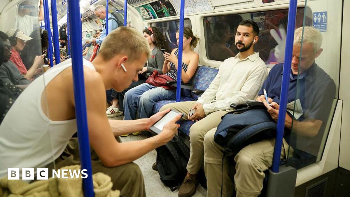 Prime Minister Mark Carney, wearing a black suit jacket, and a white button-up shirt leans his chin on his hands. He has short grey and black hair and is looking away from the camera.
