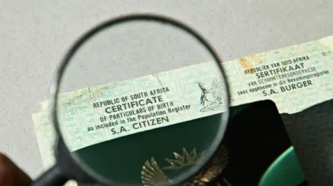 Getty Images A South African birth certificate can be seen through a magnifying glass.