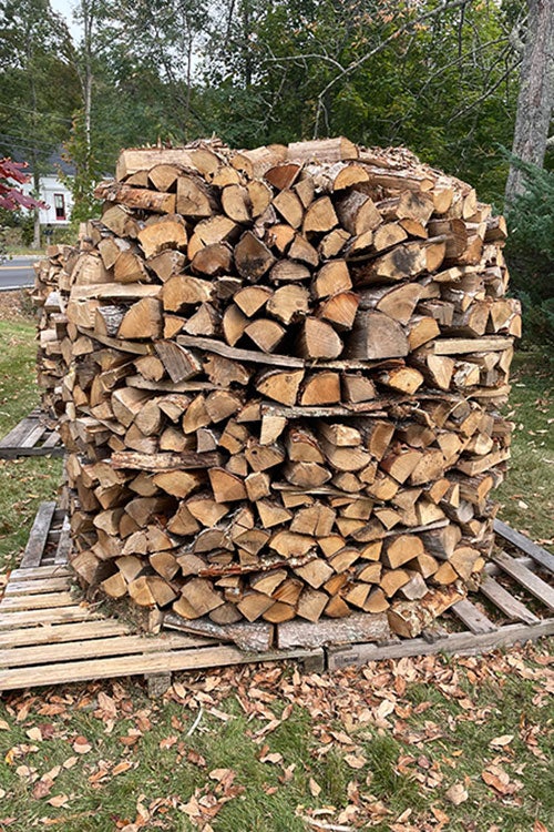 Late in the holzhausen building stage: a tall circular stack of wood.