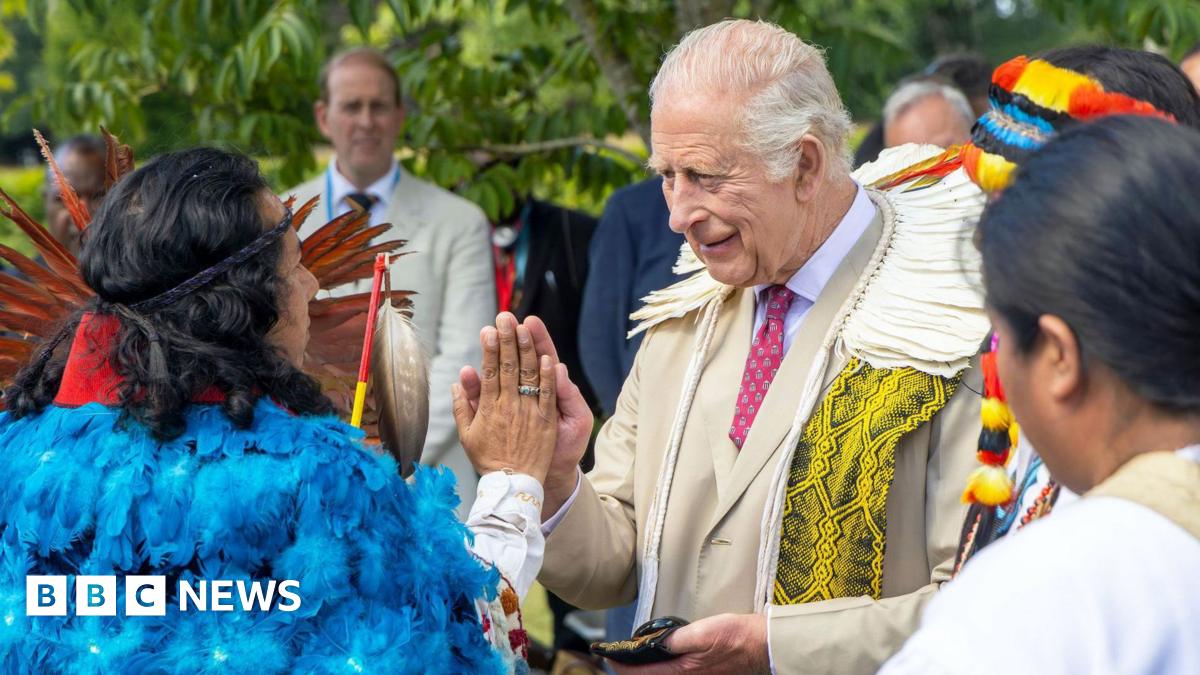 King Charles in a summer suit holds a shepherd's crook