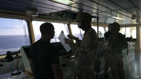 French Joint Staff of the Armed Forces Soldiers talk to people on the oil tanker