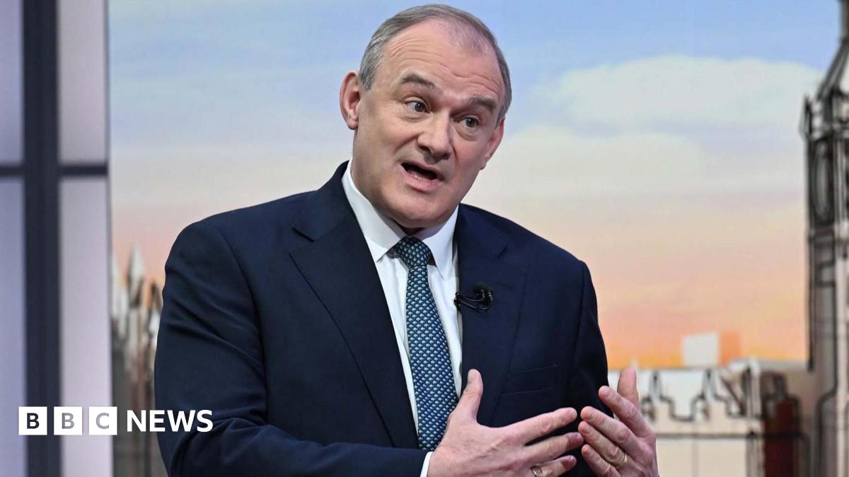 Sir Ed Davey sat in a navy suit with a blue patterned tie, in conversation during the Sunday with Laura Kuenssberg panel show