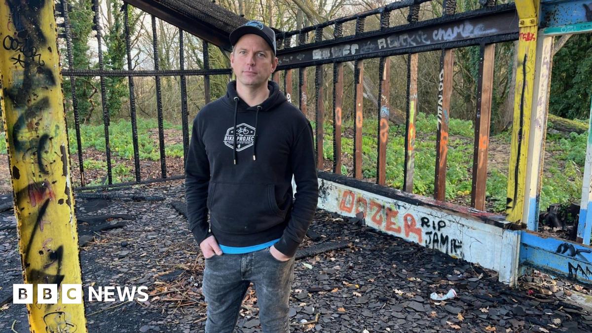 Steve Farmer pictured at the proposed site of his community cycle park at the former golf course at Broadwater Park, Farncombe. Steve is stood with his hands in his pockets and is wearing jeans, a black hoodie and a cap.