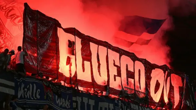 Strasbourg fans hold up a banner reading 'BlueCo out'