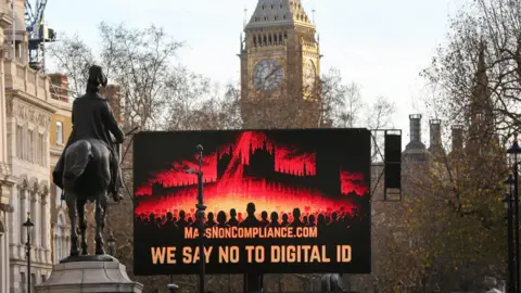 Getty Images A large screen says "We Say No To Digital ID" in front of the Elizabeth Tower in Whitehall