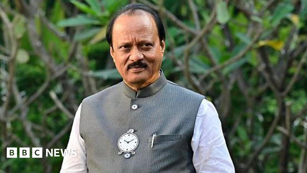 Ajit Pawar poses for a picture at the garden in his residence on January 13, 2026 in Pune. He's wearing a white kurta with a dark grey vest that has the image of a clock and pen in his left pocket