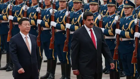 Getty Images Chinese President Xi Jinping (R) and Venezuela's President Nicolás Maduro Moros (L) walk side by side in black suits during a welcoming ceremony outside the Great Hall of People on September 22, 2013 in Beijing, China.