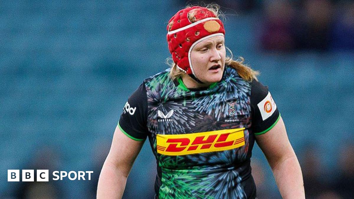 Harlequins' Aoife Wafer wears a red protective head cover during a match