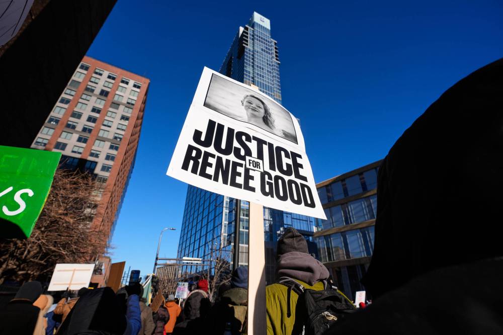 ALEX BRANDON / THE ASSOCIATED PRESS
A protestor holds a sign referencing 37-year-old Renee Good, who was fatally shot by a federal agent as she attempted to drive away from an encounter with ICE officers.