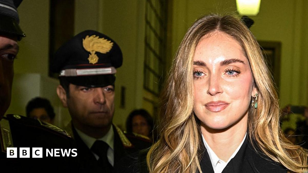 Chiara Ferragni is surrounded by press holding cameras and microphones as she  arrives at a courthouse in Milan.