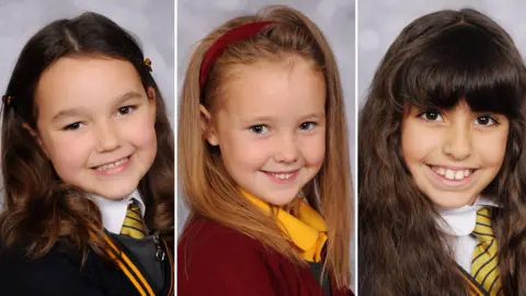 Family photos A composite image of Bebe King, Elsie Dot Stancombe and Alice Aguiar all in their school uniforms and smiling. Bebe has her long dark hair clipped back, Elsie has a red headband in her long blonde hair, and Alice has a dark wavy hair and a fringe. 