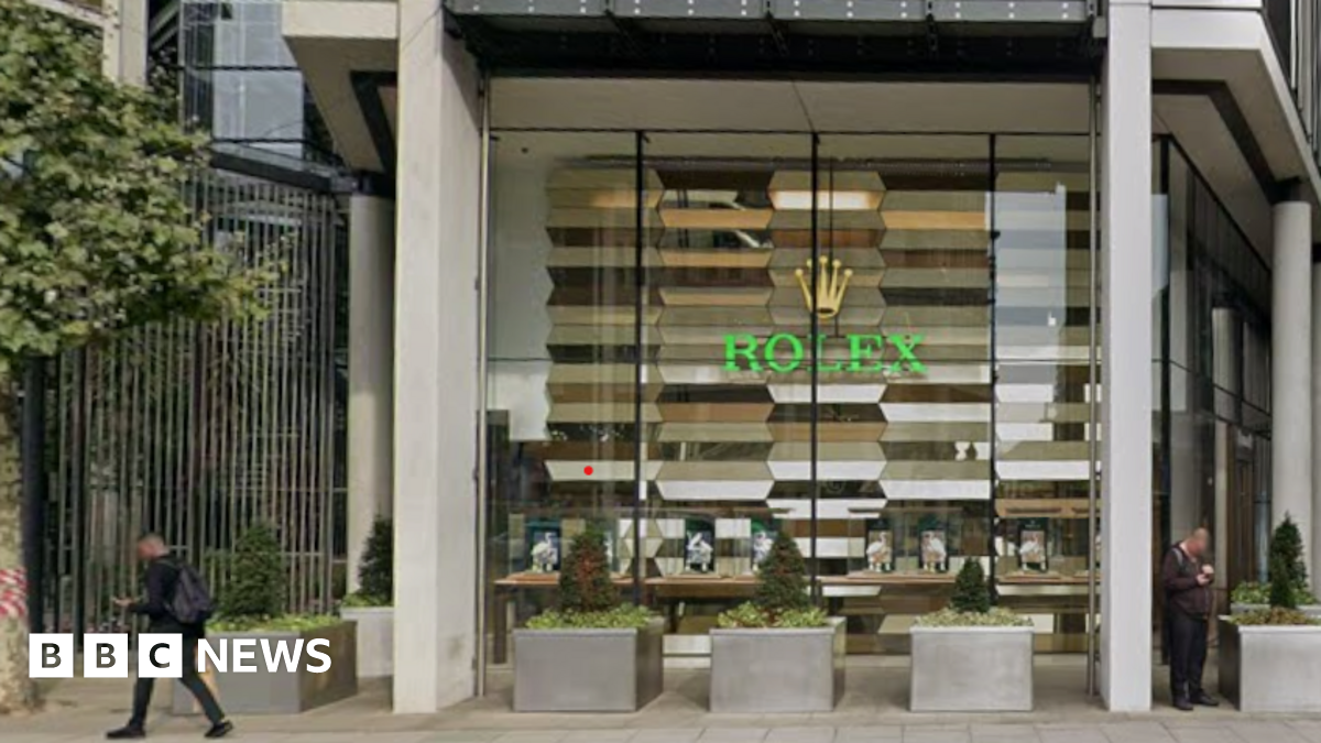 Glass-fronted shop bearing Rolex logo and name in the window